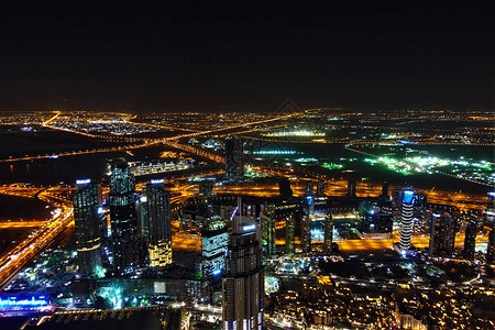 从高处看迪拜全景夜晚摩天大楼和昂贵的不同颜色的明亮照明黑色天空映衬下图片