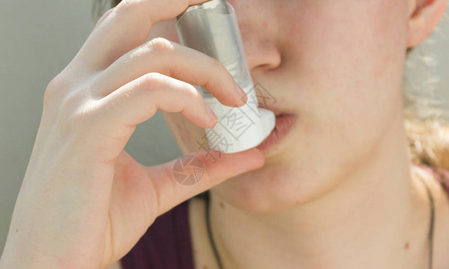 使用哮喘吸入器的少女图片