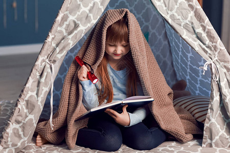 小女孩晚上在帐篷里看书图片