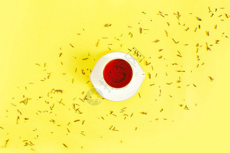 陶瓷杯冲泡的茶叶子和干草本散落在白色背景上早茶仪式的概念平躺组成创意图片