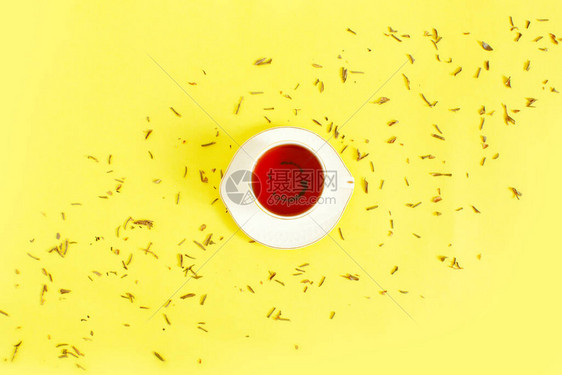 陶瓷杯冲泡的茶叶子和干草本散落在白色背景上早茶仪式的概念平躺组成创意图片