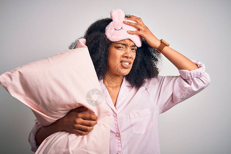 身着睡衣和睡面具的非洲年轻女头顶枕头被用手压住图片