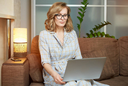 一位戴眼镜的年轻女子在她公寓的台式电脑上远程工作一位女士在家中进行视频商务简报会听在线讲座图片
