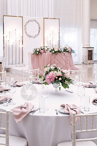 婚礼午餐豪华的圆桌会议装饰着鲜花和时髦的餐盘图片