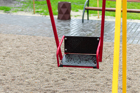 雨中操场上空荡的秋千公园里的儿童秋千木凳滑梯运动器材空城图片