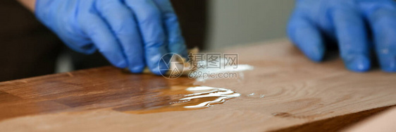 木工手的特写镜头在防护手套覆盖木表面细木工上漆家具的一部分木工作和细图片