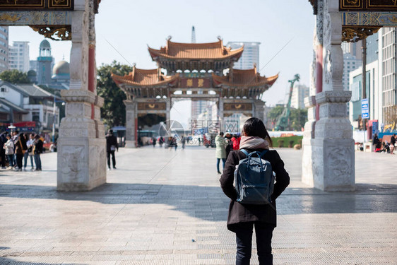 在金碧广场金马和玉鸡牌坊旅行的年轻女子旅行者图片