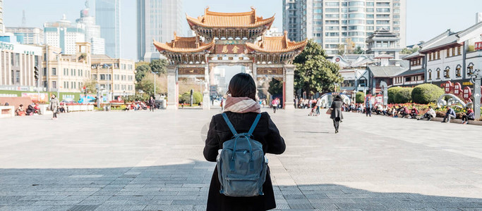 在金碧广场金马和玉鸡牌坊旅行的年轻女子旅行者图片