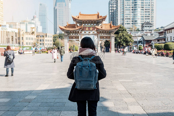 在金碧广场金马和玉鸡牌坊旅行的年轻女子旅行者图片