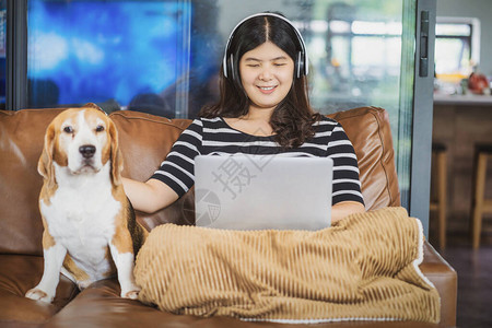 亚洲女商人使用技术笔记本电脑和耳机在家中通过视频电话会议在家工作图片