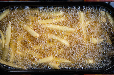 炸薯条用含沸油的煎在电动背景图片