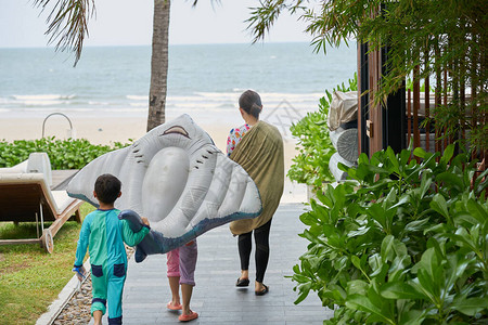 度假时带玩具漂浮者去海滩旅行家图片