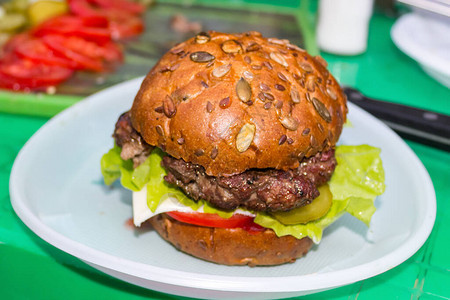 开胃新鲜自制汉堡肉奶酪和生菜在一张绿色的桌子上美味的快餐概念图片