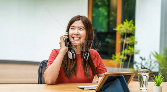 亚洲女商人使用带键盘的手机图片