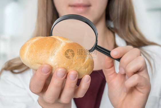 科学家用放大玻璃检查一个面包食品中不健图片
