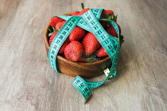 圆木板上美味的大红草莓已经用磁带计数了1厘米累坏了饮食和消瘦的方式健图片