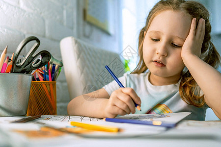 可爱的小女孩用彩色铅笔画了一幅画一个孩子画一本图画书缓解压力的新趋势发展注意力背景图片