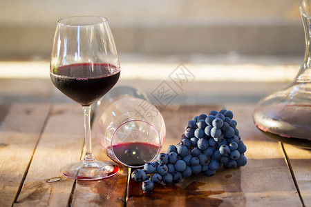 杯红葡萄酒配紫葡萄背景图片