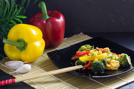 亚洲食物炒薯条和蔬菜酱油辣椒以及竹垫图片