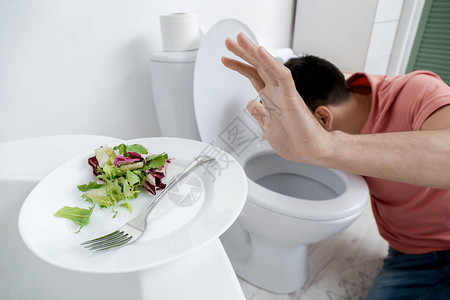青年男子在厕所碗和浴室沙拉盘子附近有厌食症图片