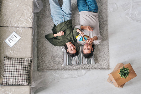 在新公寓或新房子的地板上放松地毯和讨论由妇女持有的彩色调板图片