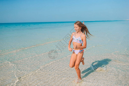 小女孩玩得开心在热带海滩图片