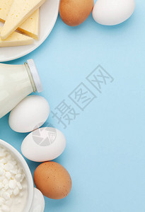 蓝色背景的乳制品牛奶小屋奶酪和鸡蛋顶视图图片