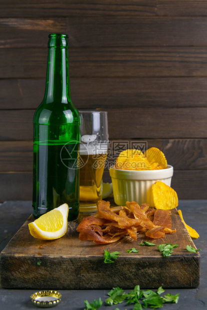 秘鲁鱿鱼和啤酒柠檬和薯片在黑木板上鱼肉加啤酒图片