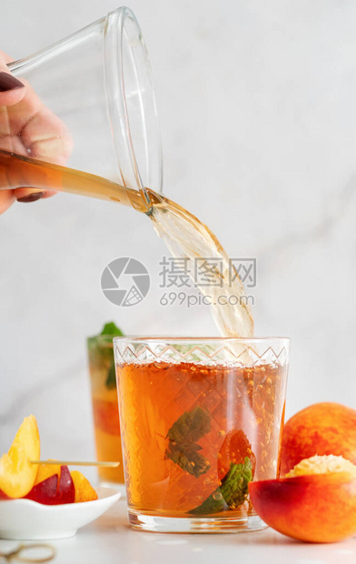 果汁加冰的冷桃子茶水果片和薄荷糖图片