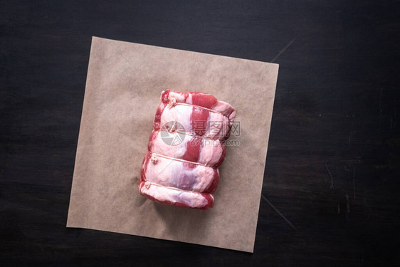 平躺在棕色屠夫纸上烤生的无骨猪肉图片