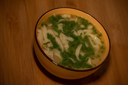 鸡肉面条汤橙色盘子里的橙色桌布上的鸡肉和面条汤美食摄影热菜肉汤配面条鸡肉背景图片