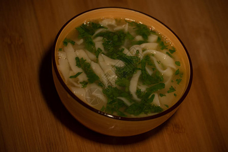 鸡肉面条汤橙色盘子里的橙色桌布上的鸡肉和面条汤美食摄影热菜肉汤配面条鸡肉背景图片