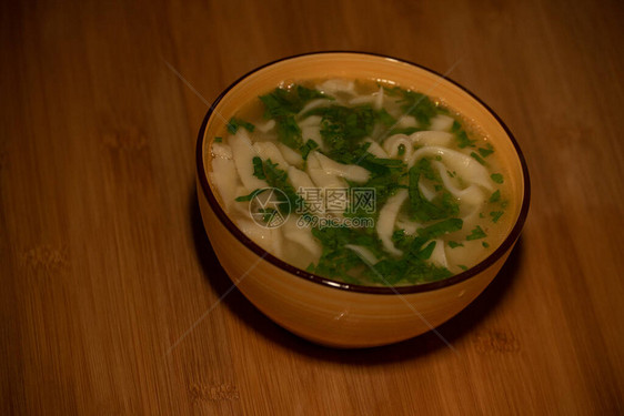 鸡肉面条汤橙色盘子里的橙色桌布上的鸡肉和面条汤美食摄影热菜肉汤配面条鸡肉图片