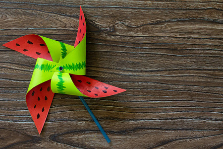 玩具,有趣的玩具西瓜风车在木桌上旋转儿童艺术项目针线活背景