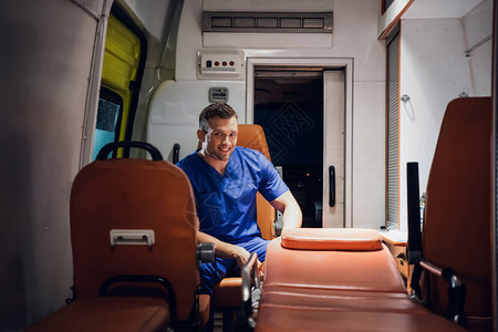 穿着医疗制服的男子坐在救护车图片