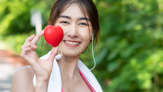 美丽的亚洲女孩在运动服快乐和微笑慢跑后手牵的特写图片