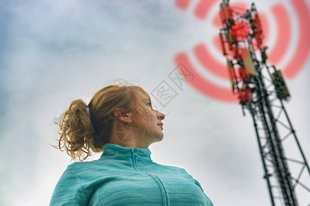 该妇女正站在BTS附近蜂窝5G网络发射机的图片