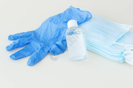 防护用品蓝色医用口罩和手套浅色背景的白色消毒剂瓶防止细菌冠状的保护和预防措施医疗保健概念图片