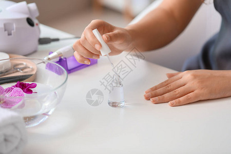 女人在指甲上涂凝胶抛光剂特写图片