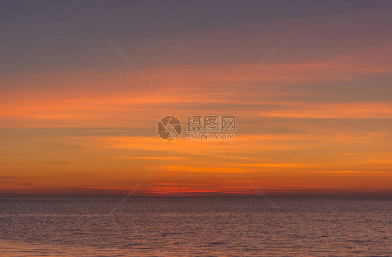 明亮的暮色日落天空在海面上日落后橙色调的美妙天空自然背景海洋和天空的紫色调图片