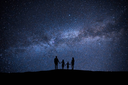 站在风景如画的星空背景上的一家人图片