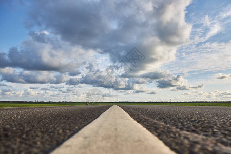 空沥青路在美丽的阴云的天空图片