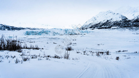 马塔努斯卡冰川在冬天被群山和雪包围的全景沿着通往冰洞的小路远足时从远处拍摄的它空虚而寂寞在阿拉斯加的图片