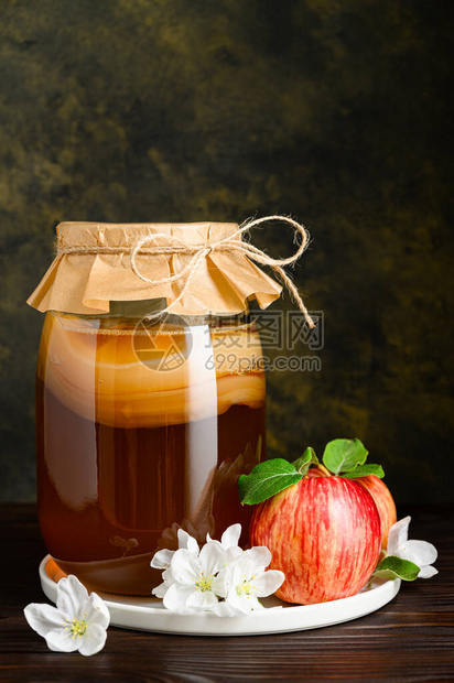 在玻璃罐里自制发酵的甘巴沙和生化背景的红苹果健康的先生饮料垂直方图片