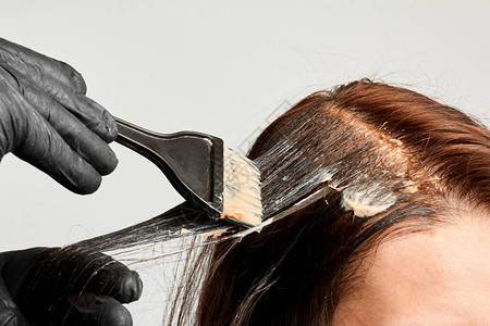 美发师用黑色刷子给女人染头发布鲁内特改变头发颜色老公图片