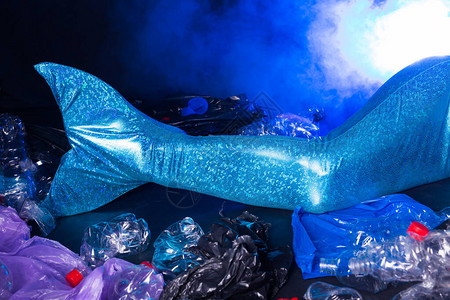 被污染的海洋中悲伤的童话美人鱼塑料垃圾和水中的垃圾环境问题塑料袋和瓶图片