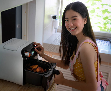 亚裔女孩在家厨房用AirFryer机图片