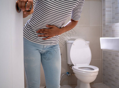 腹泻的女人站在浴室里图片