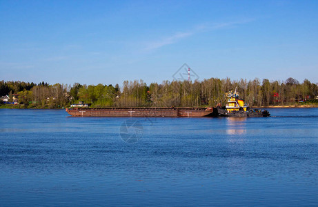 一艘拖船在泉水河上推着图片