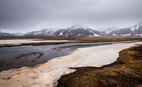 冰岛斯奈费尔森半岛雪中覆盖冰冻湖泊山丘和草地的图片